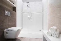 Modern compact shower surround featuring smooth, interlocking solid-surface panels and a highly functional, small-footprint design