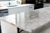 Modern waterfall island countertop featuring a seamless vertical extension that flows from the surface to the floor for a monolithic, architectural silhouette