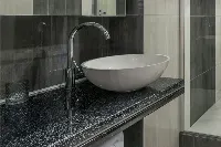 Modern granite vanity surface featuring a flat, solid deck designed specifically for a contemporary vessel sink installation