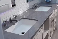Modern dual-sink vanity surface with two symmetrical undermount basins and a sleek, low-profile stone edge