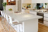 Modern multi-level island countertop featuring a tiered dual-height surface that seamlessly separates food preparation zones from casual dining spaces