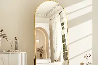 Modern arched floor mirror with a sleek metal frame for hotel suites