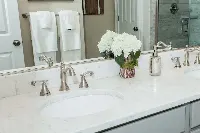 Luxury designer granite vanity surface featuring a dramatic mitered apron edge and a custom-polished natural stone grain