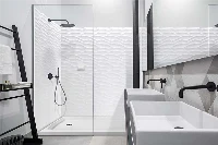 Modern glass enclosure surround featuring seamless solid-surface wall panels engineered to pair perfectly with minimalist, frameless glass hardware