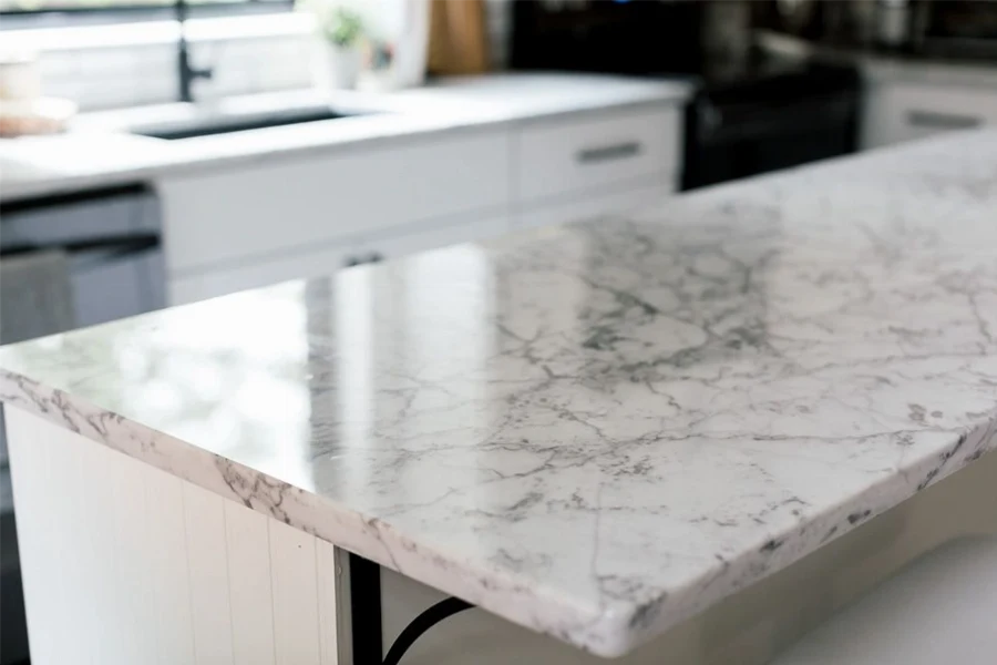 Modern waterfall island countertop featuring a seamless vertical extension that flows from the surface to the floor for a monolithic, architectural silhouette