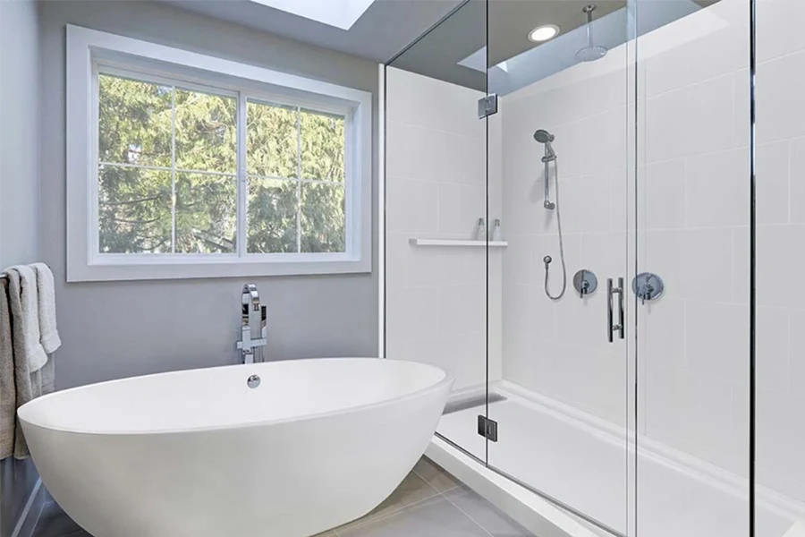 Modern freestanding surround featuring floor-to-ceiling solid-surface panels designed to wrap seamlessly behind an independent tub