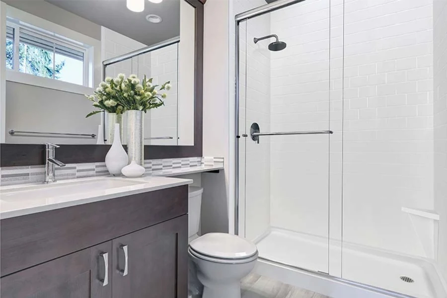Modern vanity-integrated surround featuring a continuous, grout-free solid-surface panel that transitions seamlessly from the vanity deck directly into the shower wall.