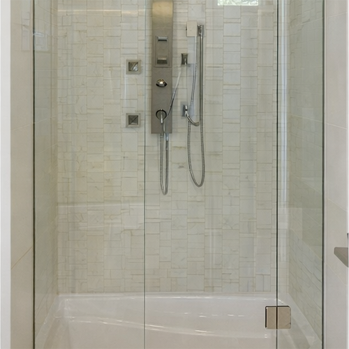 Custom granite tub surround with glass enclosure installation