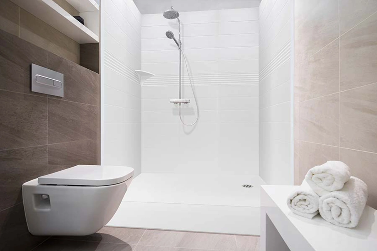 Modern compact shower surround featuring smooth, interlocking solid-surface panels and a highly functional, small-footprint design