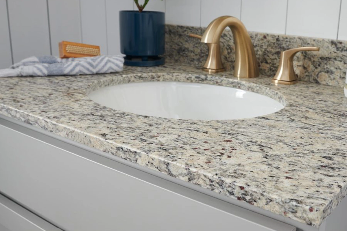 Traditional granite vanity surface featuring a decorative ogee edge and a polished natural stone finish