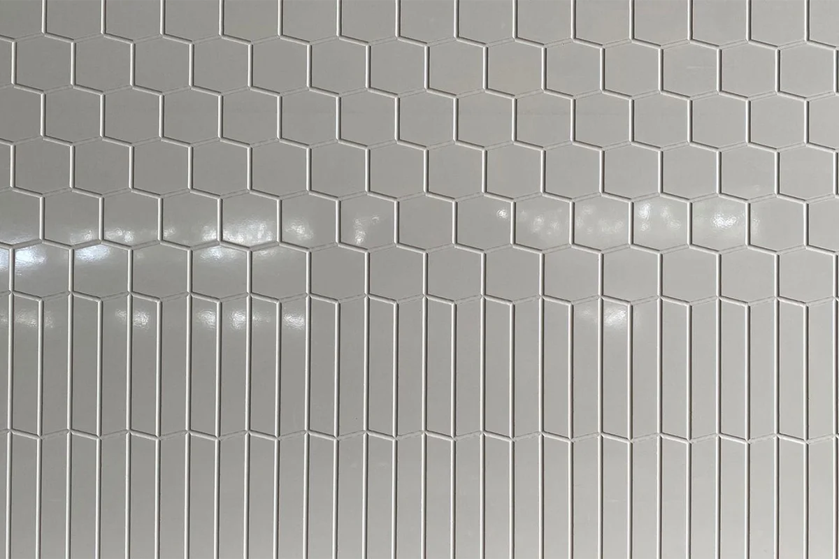Modern vertical groove panel featuring an engineered solid-surface construction and a crisp, linear pattern that visually heightens interior spaces